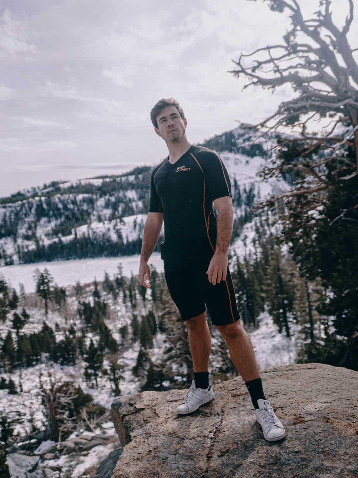 Eine Person die in den USA auf einem Berg in Winterlandschaft mit dem Anzug posiert